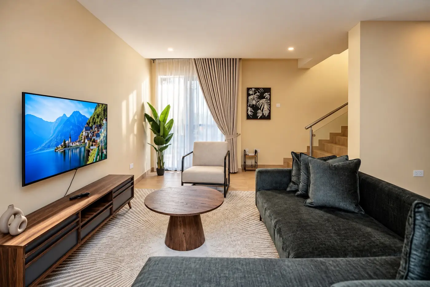 Two-bedroom lounge with a charcoal sofa, TV and staircase